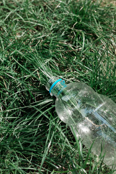 istock Ecology concept. Plastic bottles are thrown on the grass 1750400495