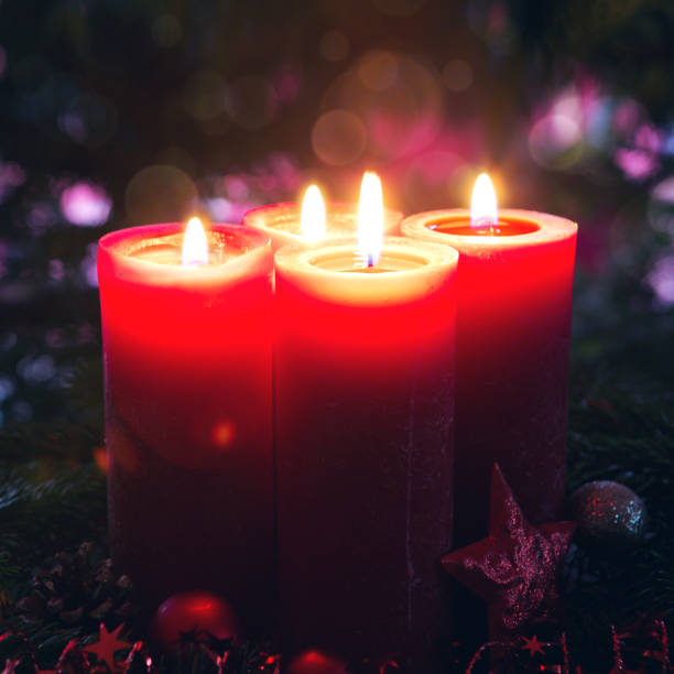 istock Four burning red Advent candles on fir tree background. 1750409627