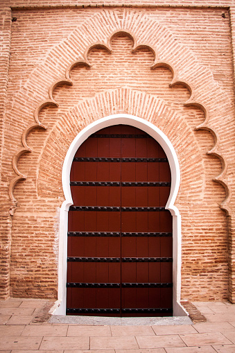 Door to a building in Marrakech, in dark red and terracotta tones. Typical Moroccan, arabic style