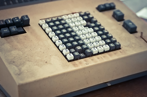 an old cash register with payment keyboard in a lost place