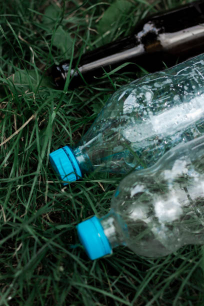 istock Ecology concept. Plastic and glass bottles are thrown on the grass 1750426789