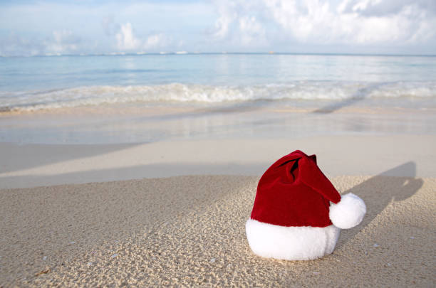 istock Merry Christmas background with red hat on the white Caribbean sand. 1750429788