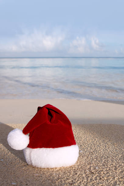 istock Merry Christmas background with red hat on the white Caribbean sand. 1750430393
