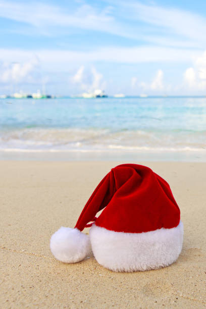 istock Merry Christmas background with red hat on the white Caribbean sand. 1750433332