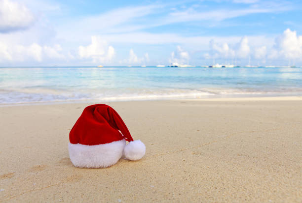 istock Merry Christmas background with red hat on the white Caribbean sand. 1750433343