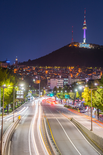The iconic spire of the Namsan Tower overlooking the warmly illuminated cityscape and busy highways below at dusk in the heart of Seoul, South Korea’s vibrant capital city.