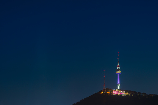 The iconic spire of Namsan Tower on the mountain at night overlooking central Seoul, South Korea’s vibrant capital city.