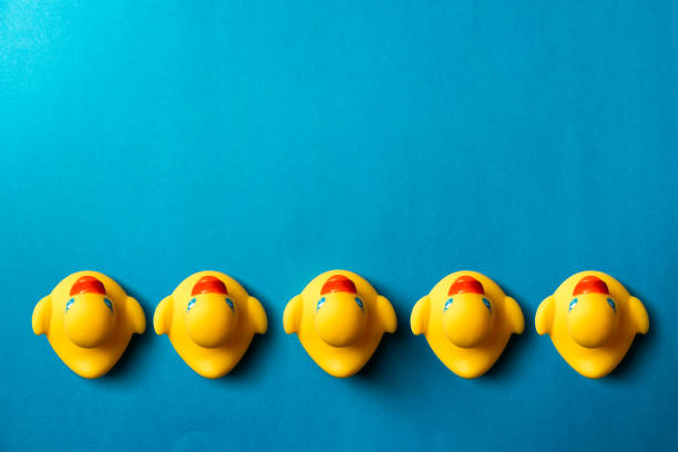 istock Yellow rubber ducks organized on blue background. 1750451182