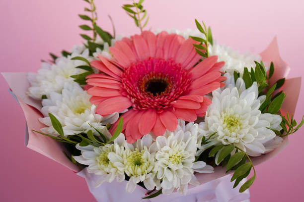 Beautiful bouquet of pink gerberas and white chrysanthemums lying on a table, perfect for a gift or decoration