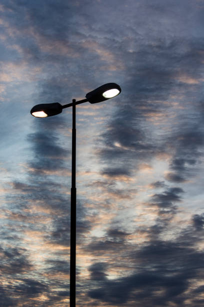 istock A modern, two light street lighting pole, still lit at dawn, under a colorful sky 1750524122