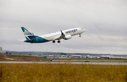 Calgary, Alberta, Canada. October 12, 2023. A WestJet Airlines Boeing 737 Max8, with identification C-GTSW, taking off from Calgary International Airport