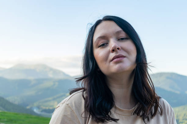 Portrait of a woman traveler standing against the background of mountains. stock photo