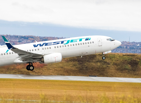 Calgary, Alberta, Canada. October 12, 2023. A WestJet Airlines Boeing 737-8CT, with identification C-FUJR, taking off from Calgary International Airport