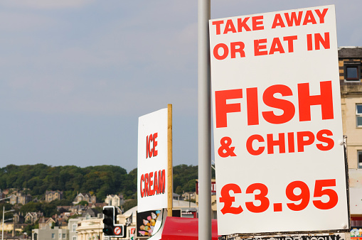 Signs outside an English seaside fish and chip shop