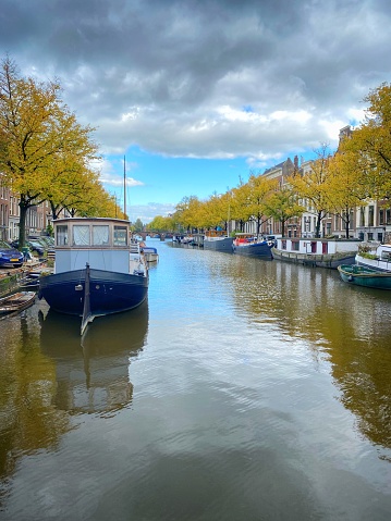 Typical canal scene of row houses and moored boats Amsterdam Netherlands