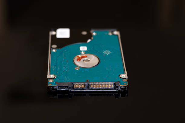 um disco rígido portátil de 2,5 polegadas em um fundo preto / disco rígido notebook - machine part built structure hard drive circuit board - fotografias e filmes do acervo