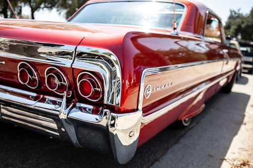 Los Angeles, CA, USA – August 21, 2022: Detail shot of red Impala rear quarter panel displaying triple circle tail lights and impala logo that was parked outdoors  in southern California