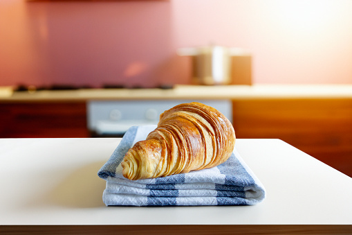 Fresh crispy croissant on a kitchen counter in a domestic kitchen