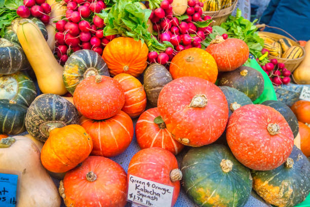 a pile of green and orange kabocha squash  at the farmer's market