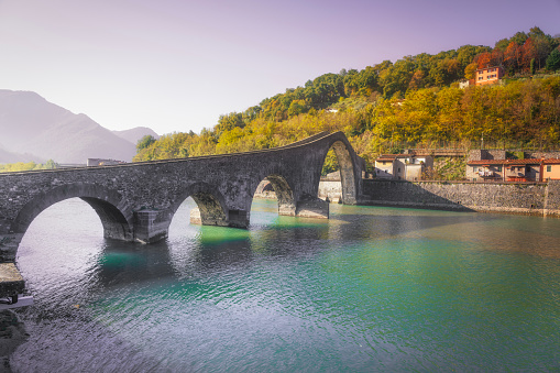 Bridge of the Devil or Ponte della Maddalena historic landmark in Garfagnana in autumn season. Serchio river. Borgo a Mozzano, Lucca. Tuscany, Italy.