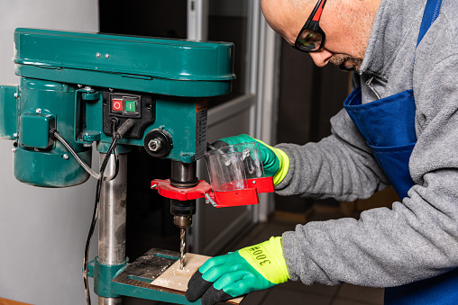 Working on vertical drilling machines in the industrial plant for producing new items