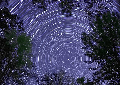 Behold the mesmerizing dance of the stars in this captivating star trails photograph facing north. Through the lens of astrophotography, the Earth's rotation reveals itself in a cosmic ballet, painting streaks of stellar light across the night sky. This celestial display is a testament to the wonders of the universe, where time seems to stand still, and the heavens come alive. Immerse yourself in the beauty of the night and let your imagination roam among the constellations.