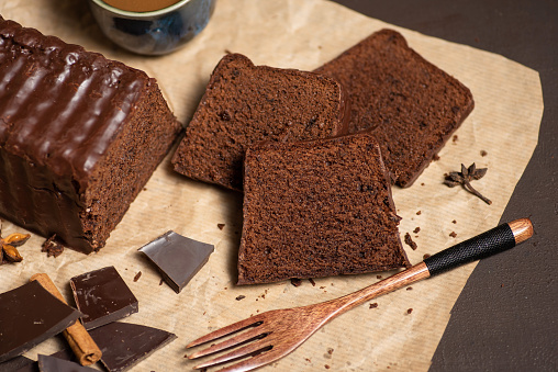 Pieces of delicious soft chocolate cake covered with melted dark chocolate on baking paper