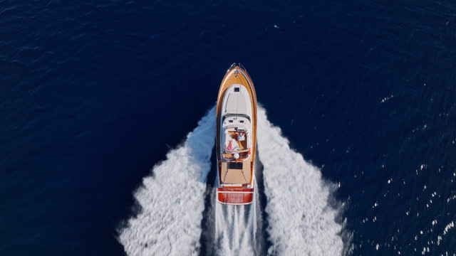 AERIAL TS Above a yacht cruising fast at sea in sunshine