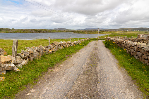 Road with Irish stone walls in Omey Island, Gooreen, Galway, Ireland