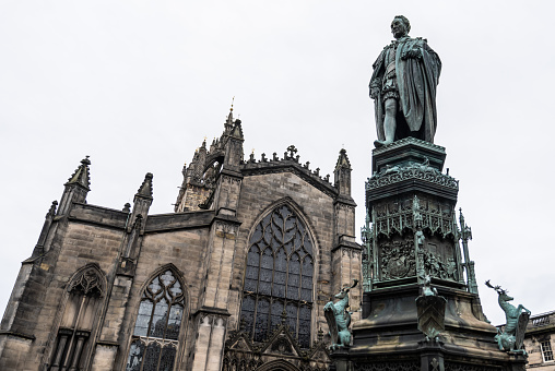 looking up at the John Knox Statue in Parliament Square, with St. Giles Cathedral in background