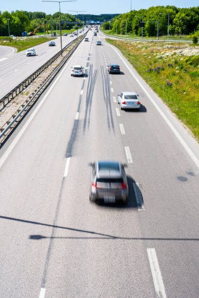 cars on a three lane highway merging into two lanes.. - two lane highway fotos imagens e fotografias de stock