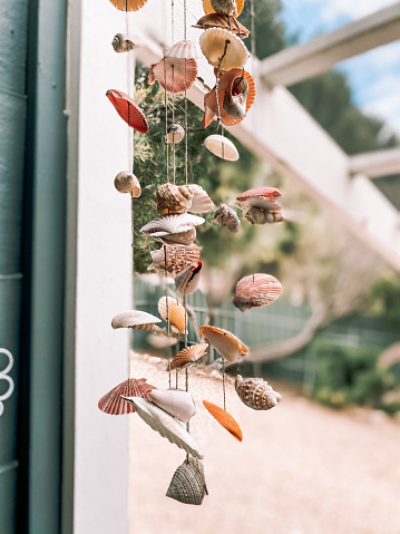 Mobile made from sea shells hanging outside at a holiday beach house