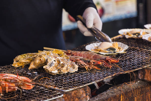 chef en una cocina callejera preparando mariscos en el mercado de tsukiji en tokio, japón - mercado tsukiji exterior fotografías e imágenes de stock