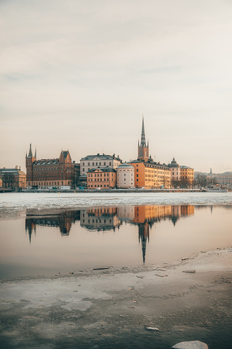 A stunning view of the Old Town (Gamla Stan) in Stockholm, Sweden, with the frozen river providing a beautiful mirror-like reflection. The picturesque winter scene captures the historic charm of this iconic European city. Old Town, Gamla Stan, Stockholm, Sweden, Frozen River, Reflection, Winter, Historic, European City, Picturesque View