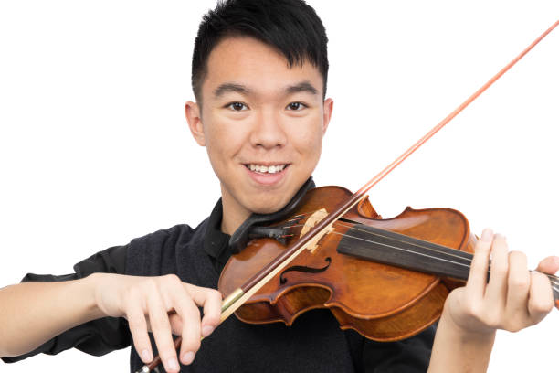 istock Smiling teenage boy playing the violin 1750921461