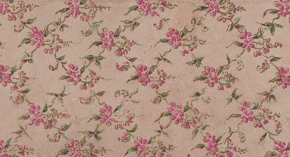 Close up of pink antique paper texture with Victorian floral pattern full frame.