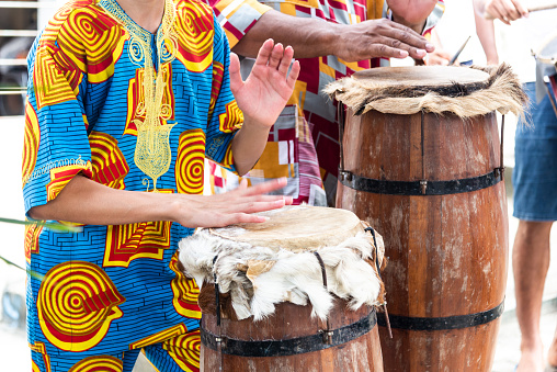 Santo Amaro, Bahia, Brazil - June 12, 2022: Members of Candomble are playing a percussion instrument during a religious demonstration in the city of Saubara, Bahia.