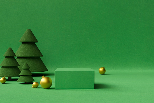 Green and gold  Christmas background with felt Christmas trees, baubles,  and copy space.