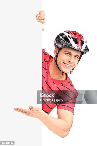 Photo libre de droit de Mâle Bicyclist Gestes Derrière Un Panneau banque d'images et plus d'images libres de droit de Adulte - Adulte, Casquette, Chapeau