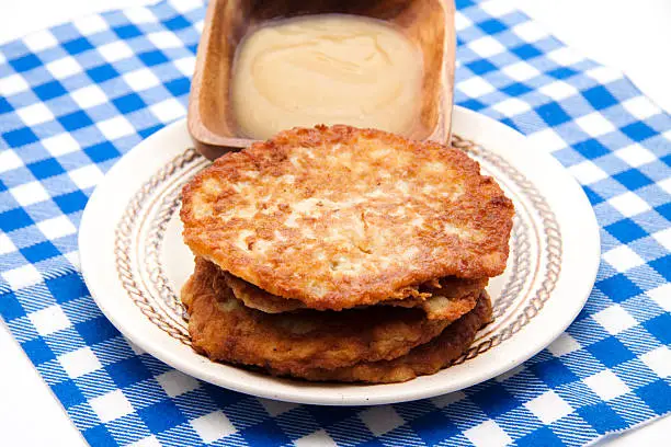 Potato pancakes and apple porridge with napkin on white background
