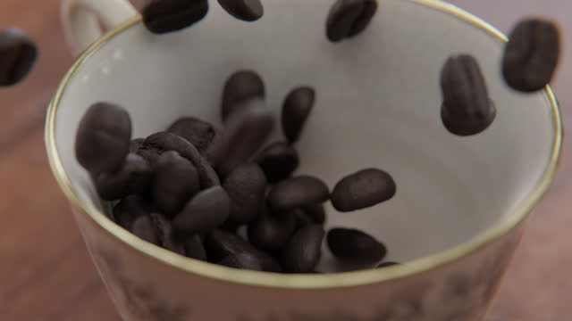 Close up of Coffee beans falling into a cup in slow motion
