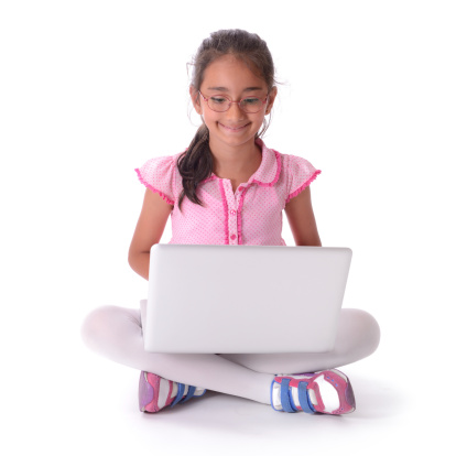 Little girl using laptop computer. Isolated on white.