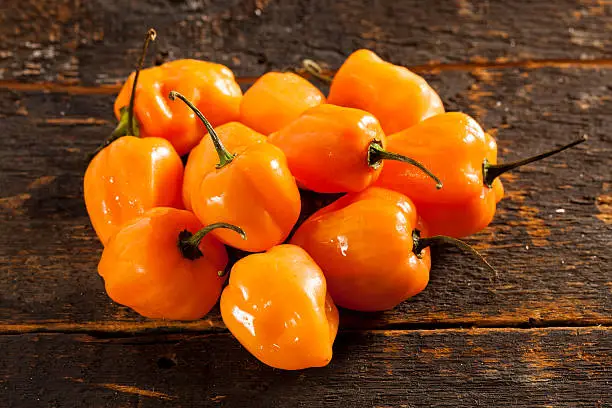 Photo of Orange Habanero peppers on a wooden table