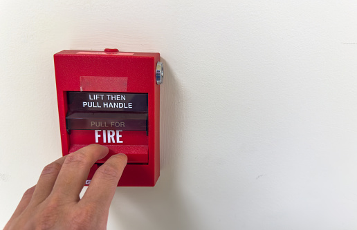 red, wall-mounted fire alarm with a glowing indicator, ready to alert in emergencies, symbolizing safety and preparedness