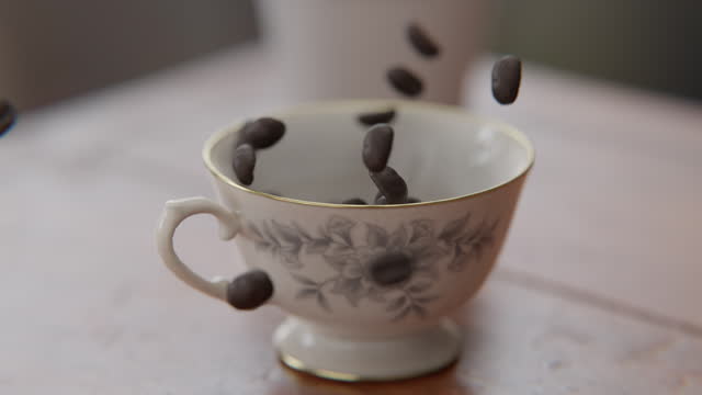 Coffee beans falling into a cup in slow motion