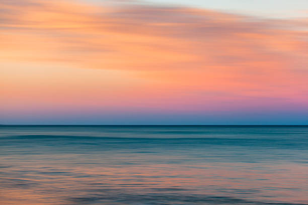 istock Motion blur of smooth calm ocean reflecting a dramatic pastel sky at dusk 1751227960