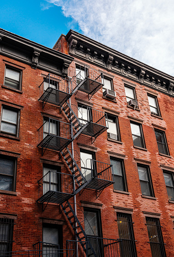 Old apartment buildings with fire escapes in New York City, USA