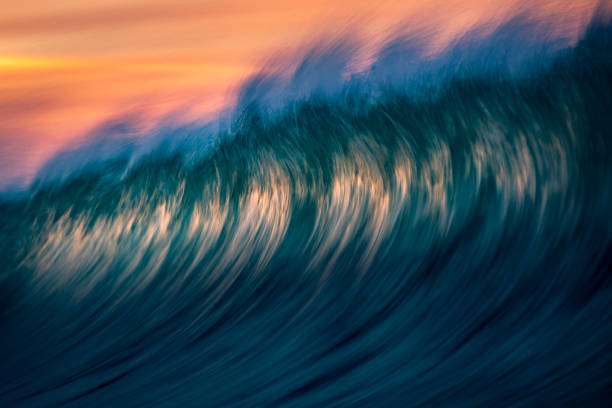 istock Motion blur of abstract wave forming in orange and gold light at sunset 1751231188