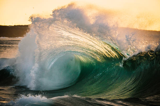 istock Ocean energy colliding and exploding into golden light forming a fan of water texture 1751232257