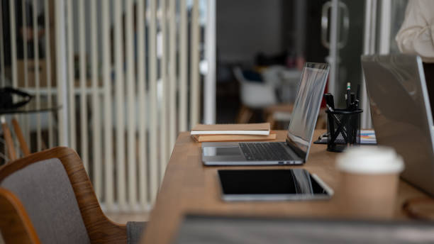 istock Side view image of a meeting table with laptops and office accessories on a modern meeting room. 1751242040